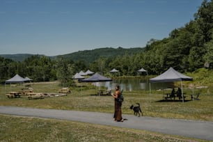 a woman is walking her dog in a park