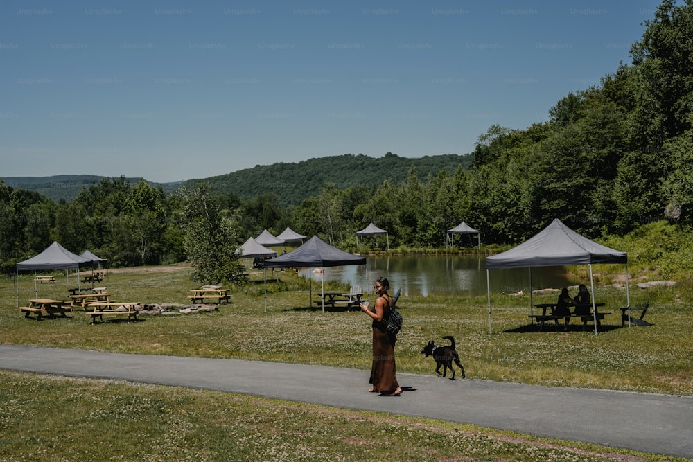 a woman is walking her dog in a park