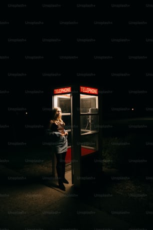a woman standing in front of a phone booth