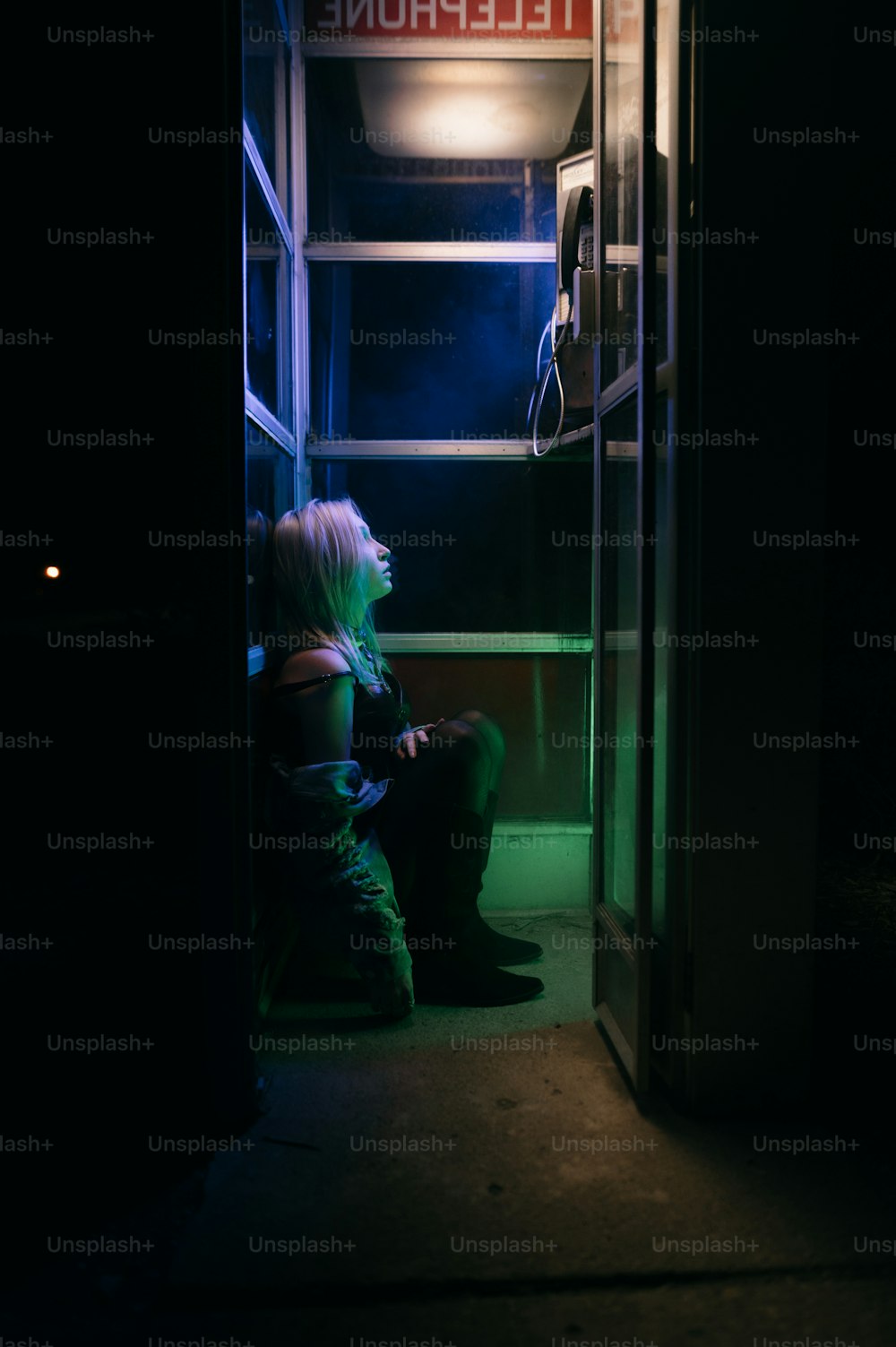a woman sitting in a doorway at night