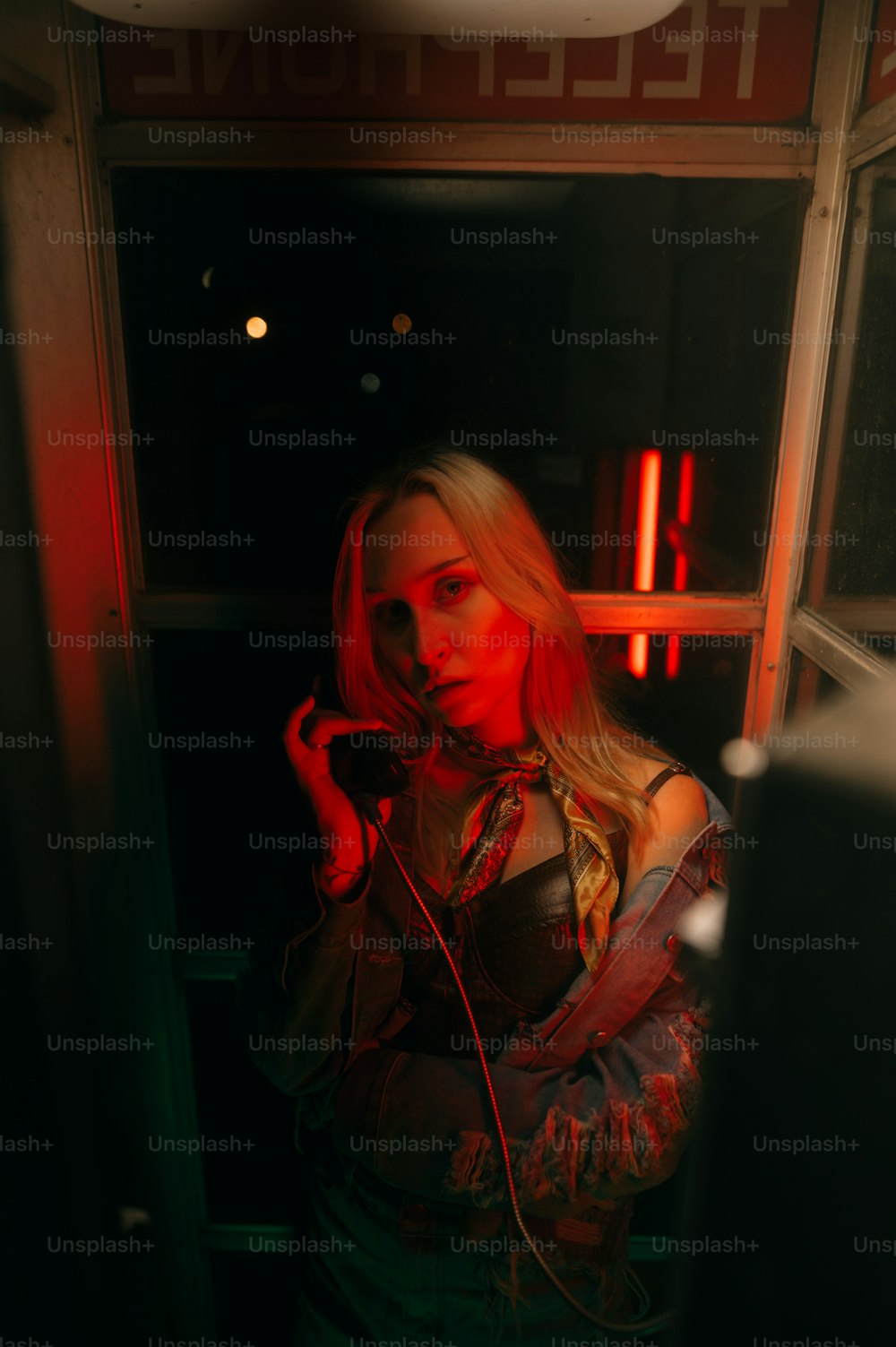 a woman in a dark room holding a cell phone