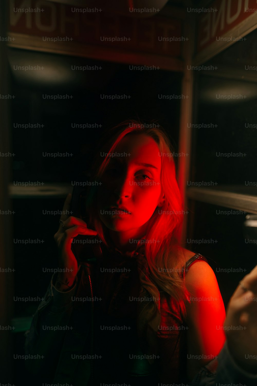 uma mulher falando ao celular em um quarto escuro