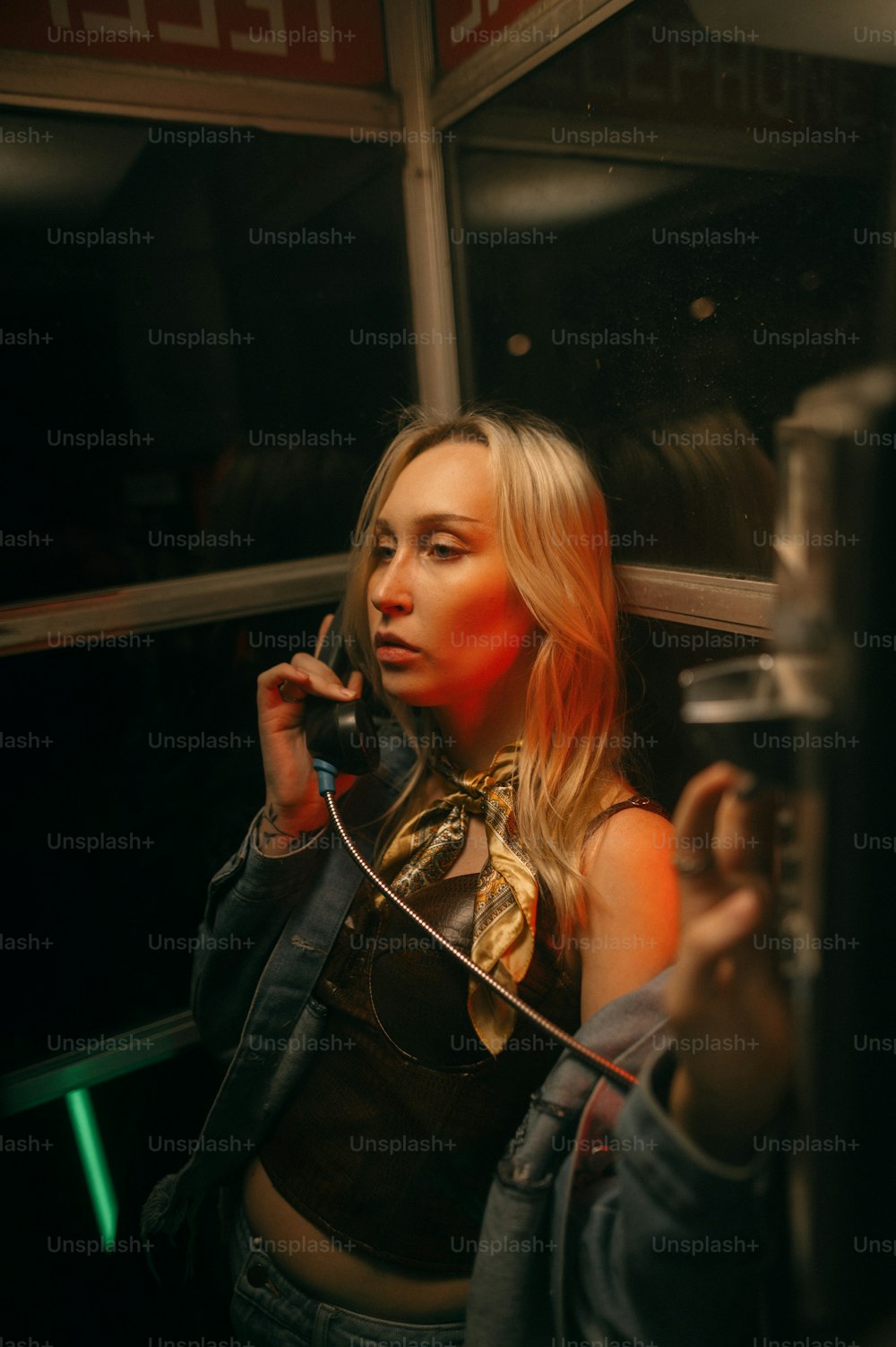 Eine Frau, die mit einem Handy telefoniert, während sie neben einem Fenster steht