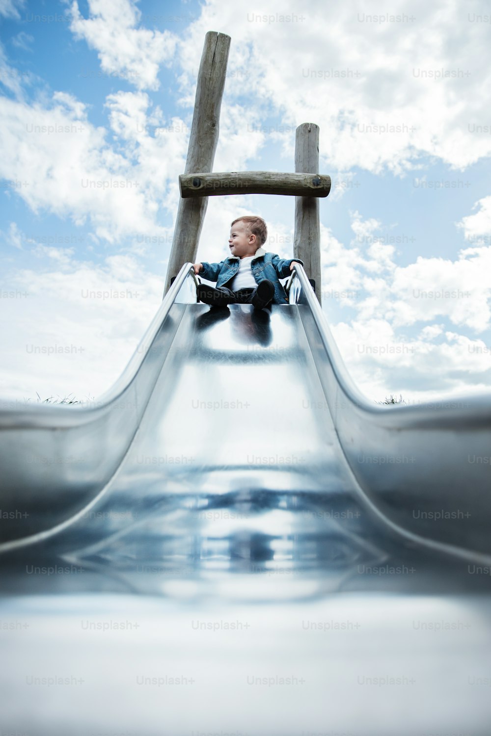 a young boy is sliding down a slide