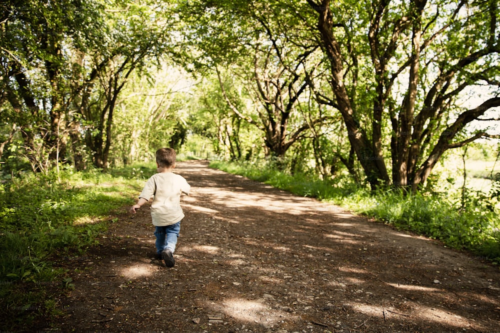 a young boy walking down a dirt road