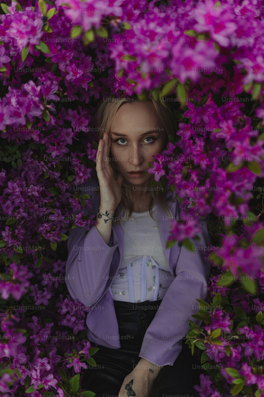 a woman in a purple jacket surrounded by purple flowers