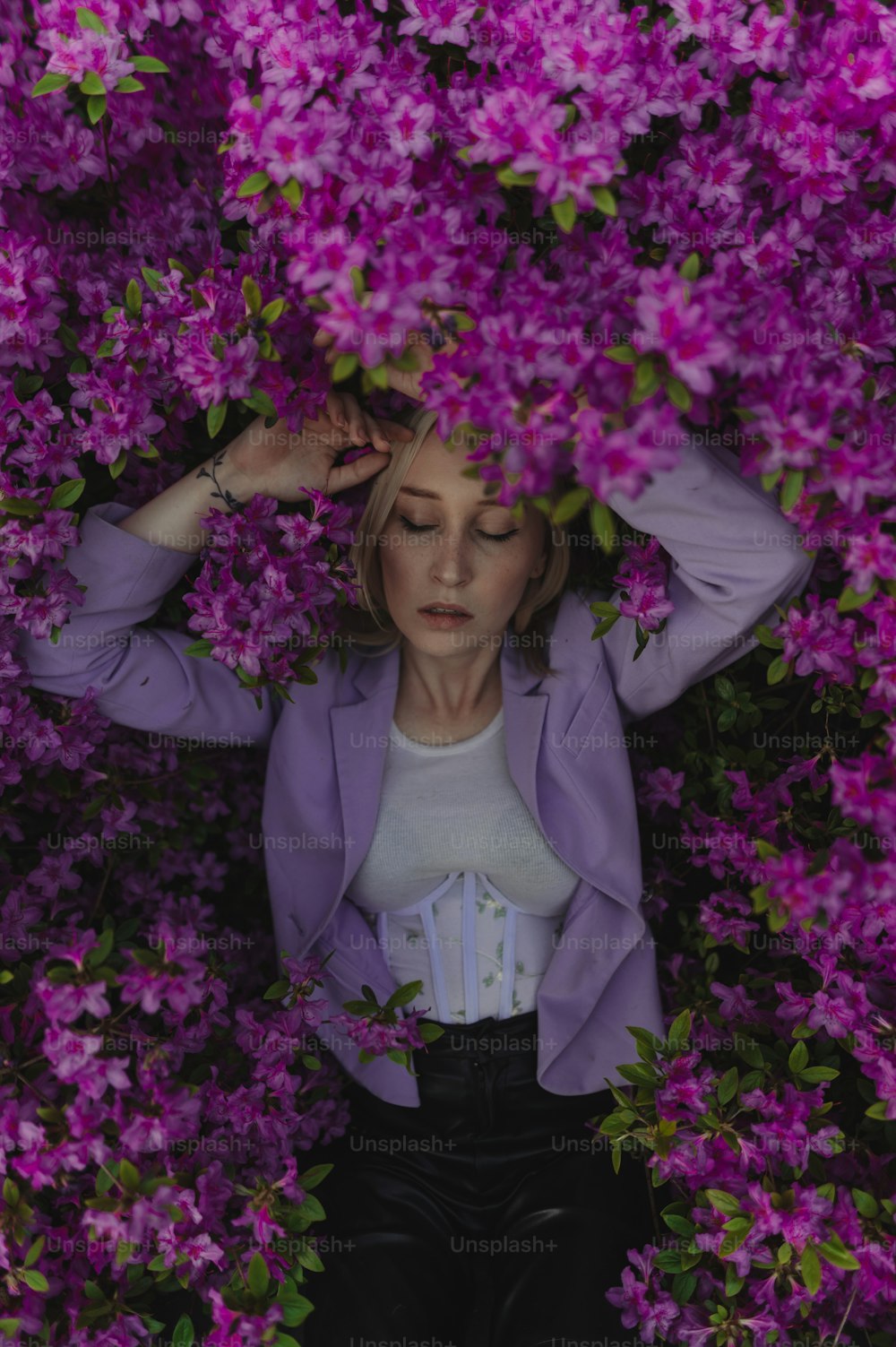 Une femme en veste violette entourée de fleurs violettes
