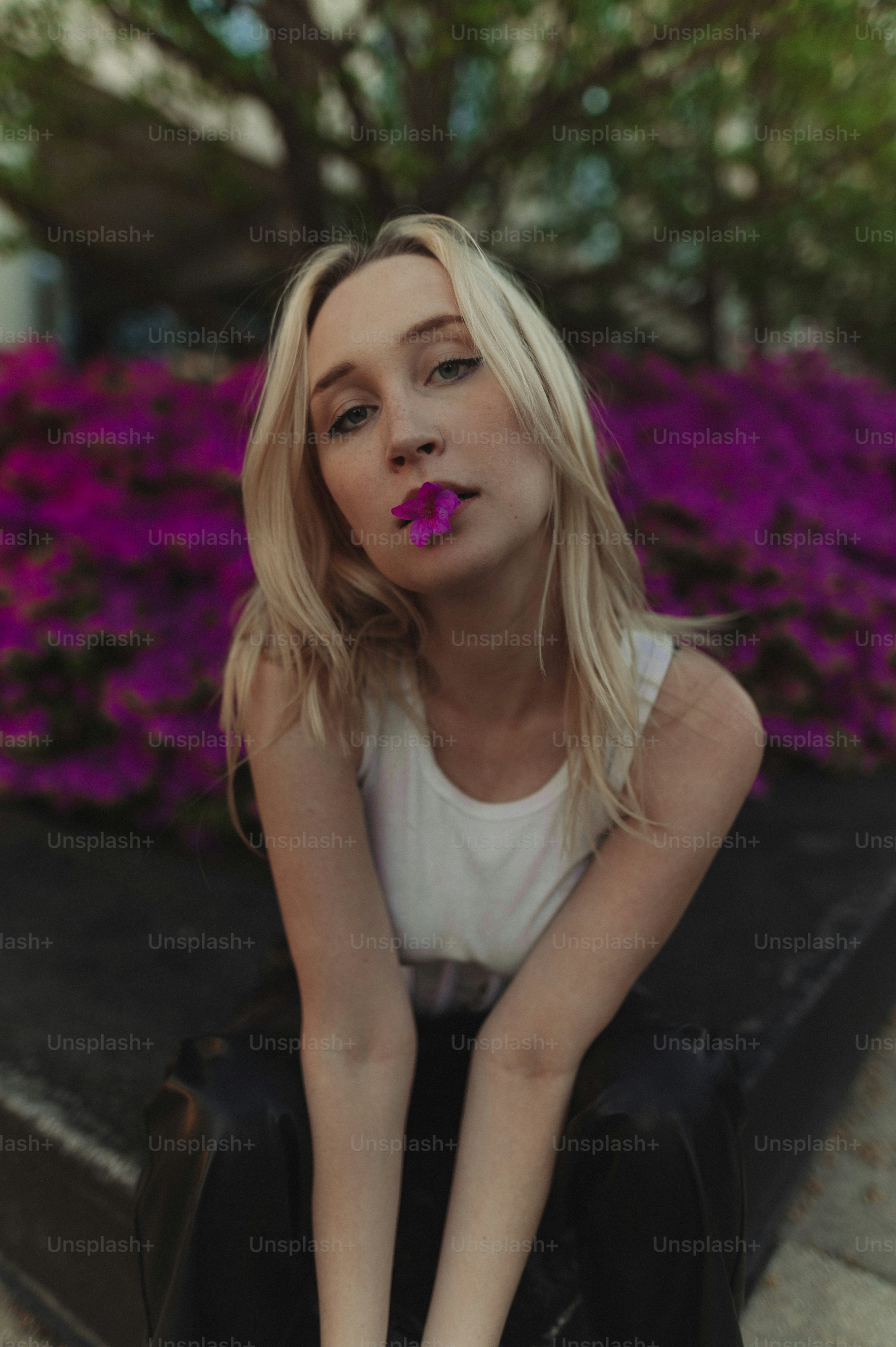 Eine Frau mit rosa Lippenstift sitzt auf einem Bordstein