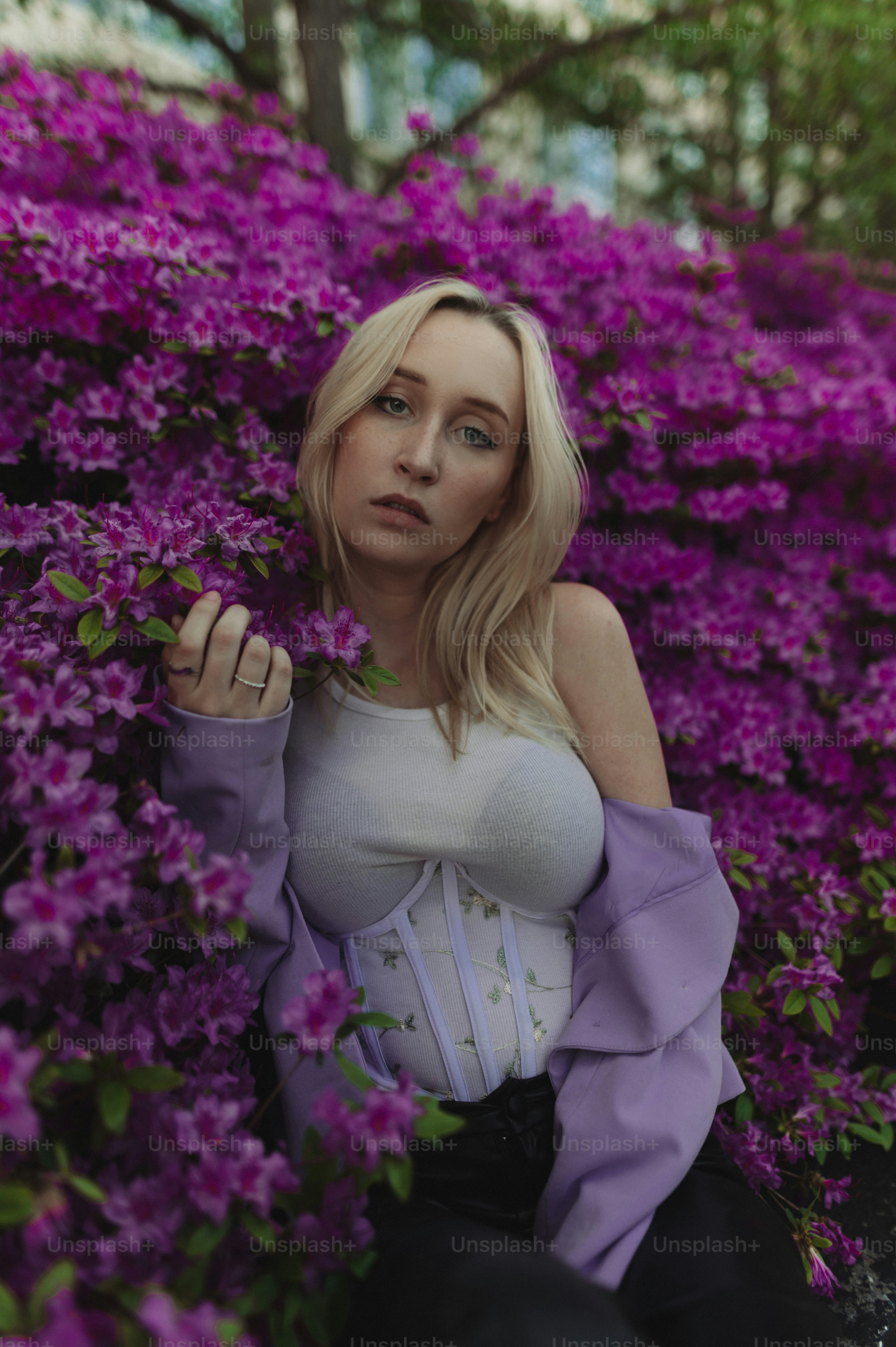 Eine Frau, die in einem Feld mit lila Blumen sitzt