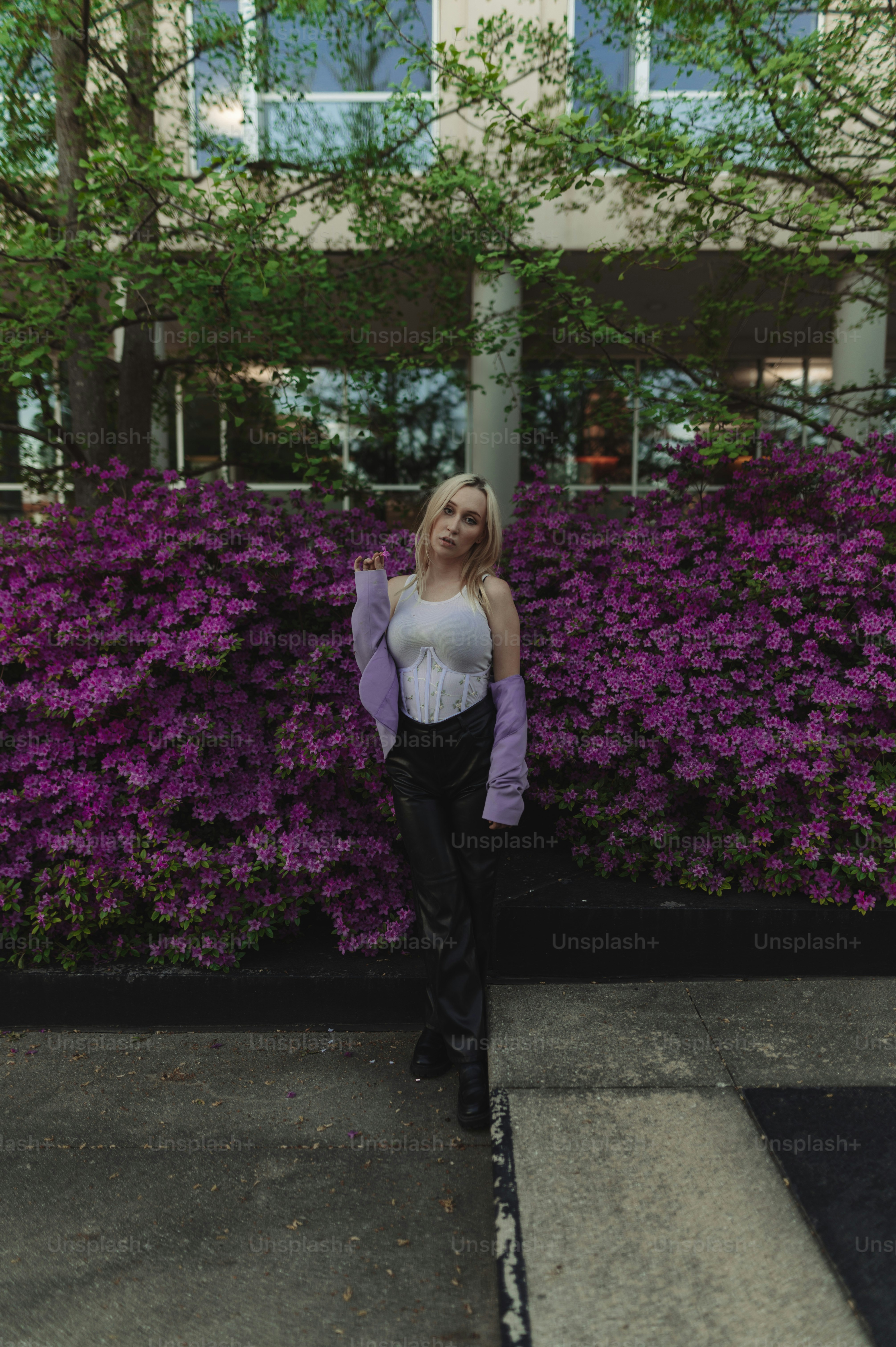 a woman standing in front of purple flowers
