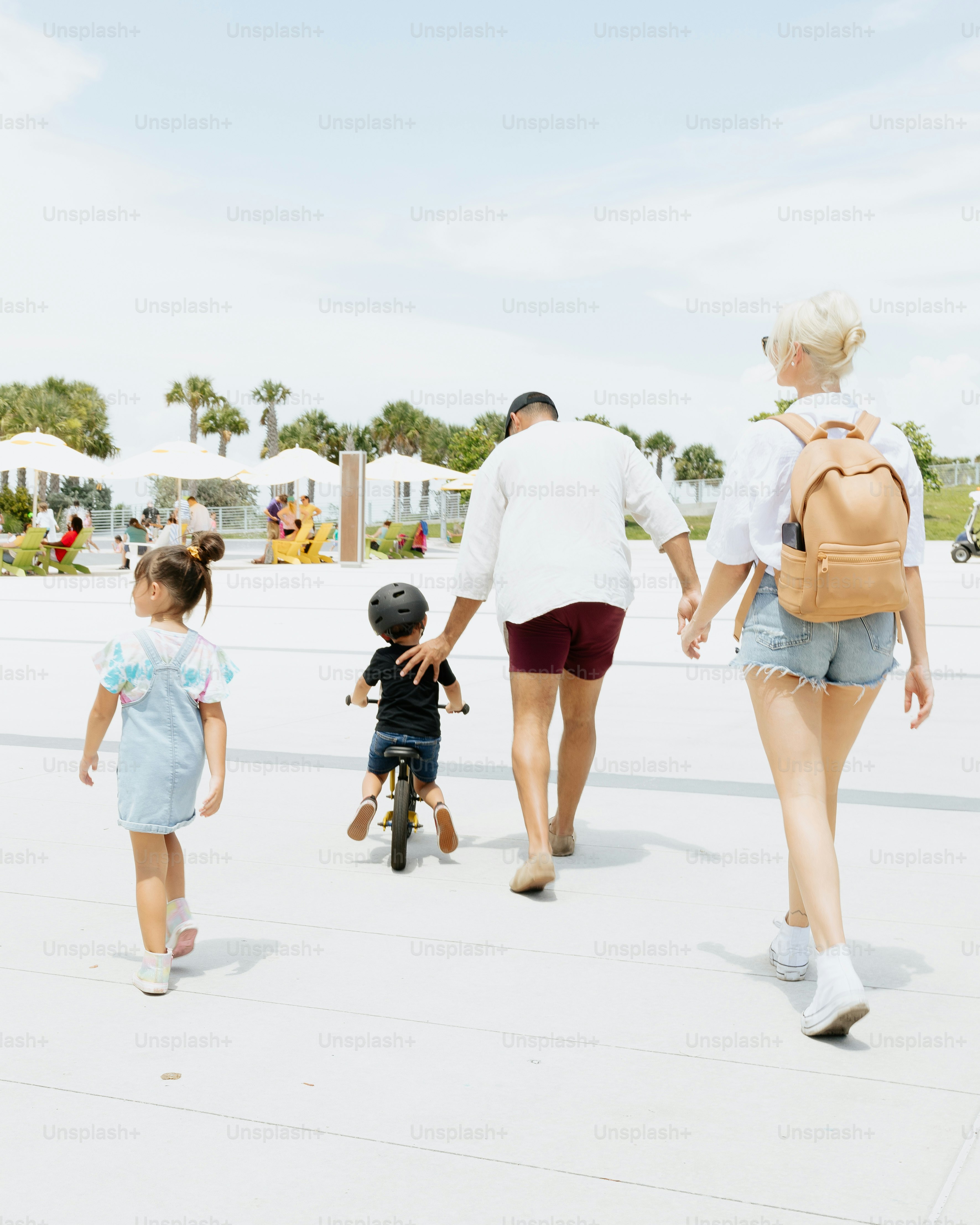 a woman and two children walking down a sidewalk