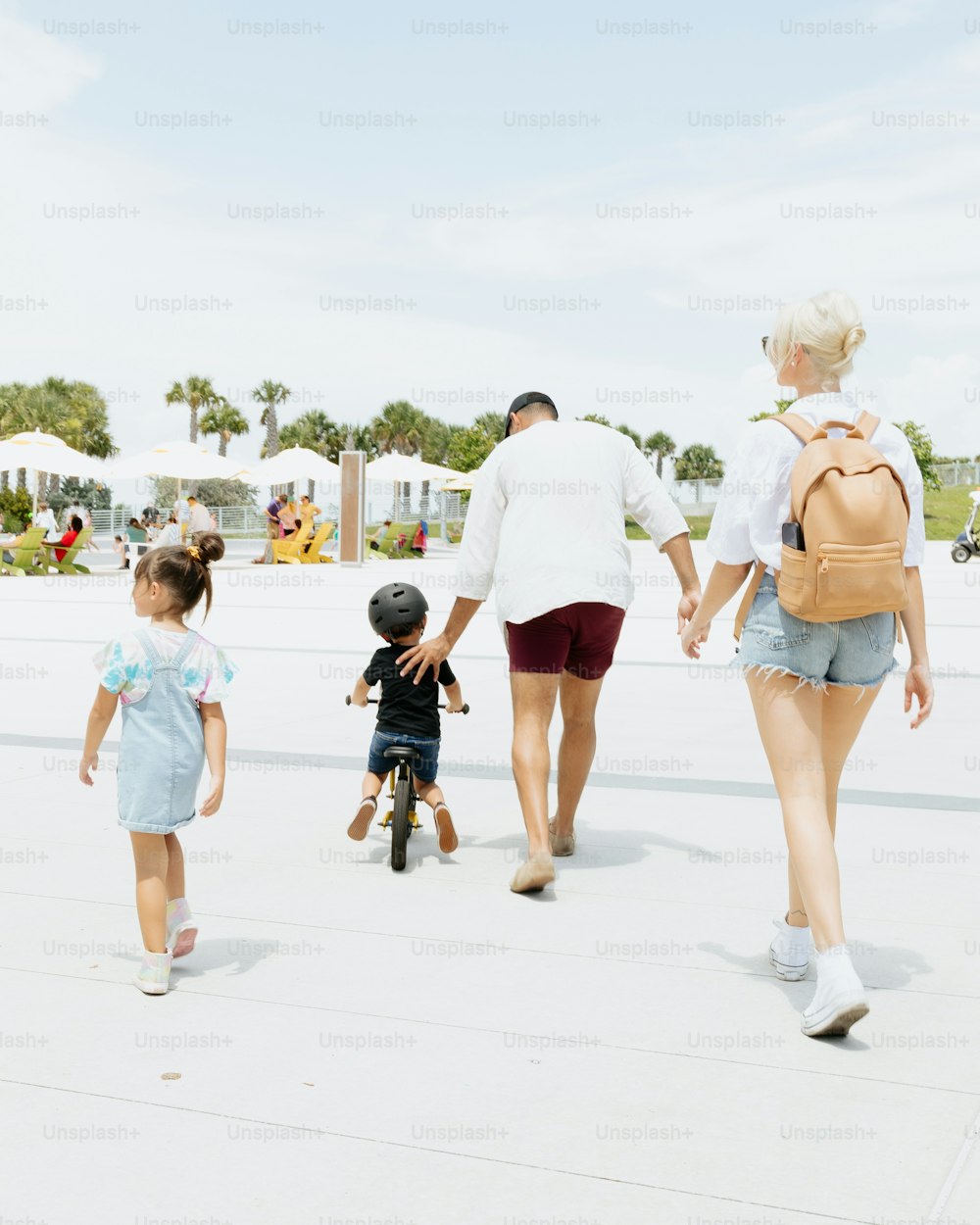 Una mujer y dos niños caminando por una acera