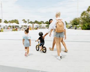 한 여자와 두 아이가 배낭을 메고 걷고 있다