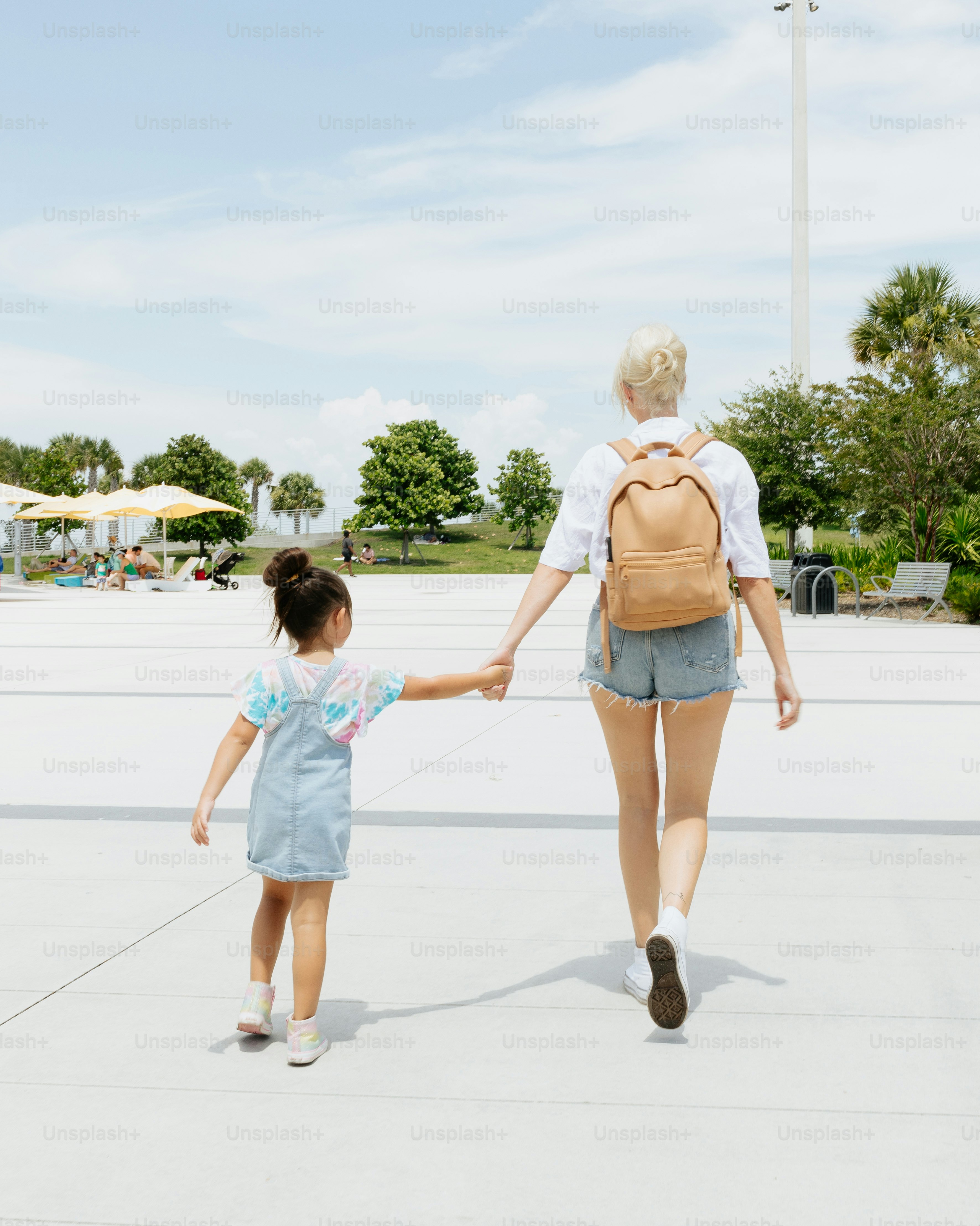 Una mujer y una niña tomados de la mano