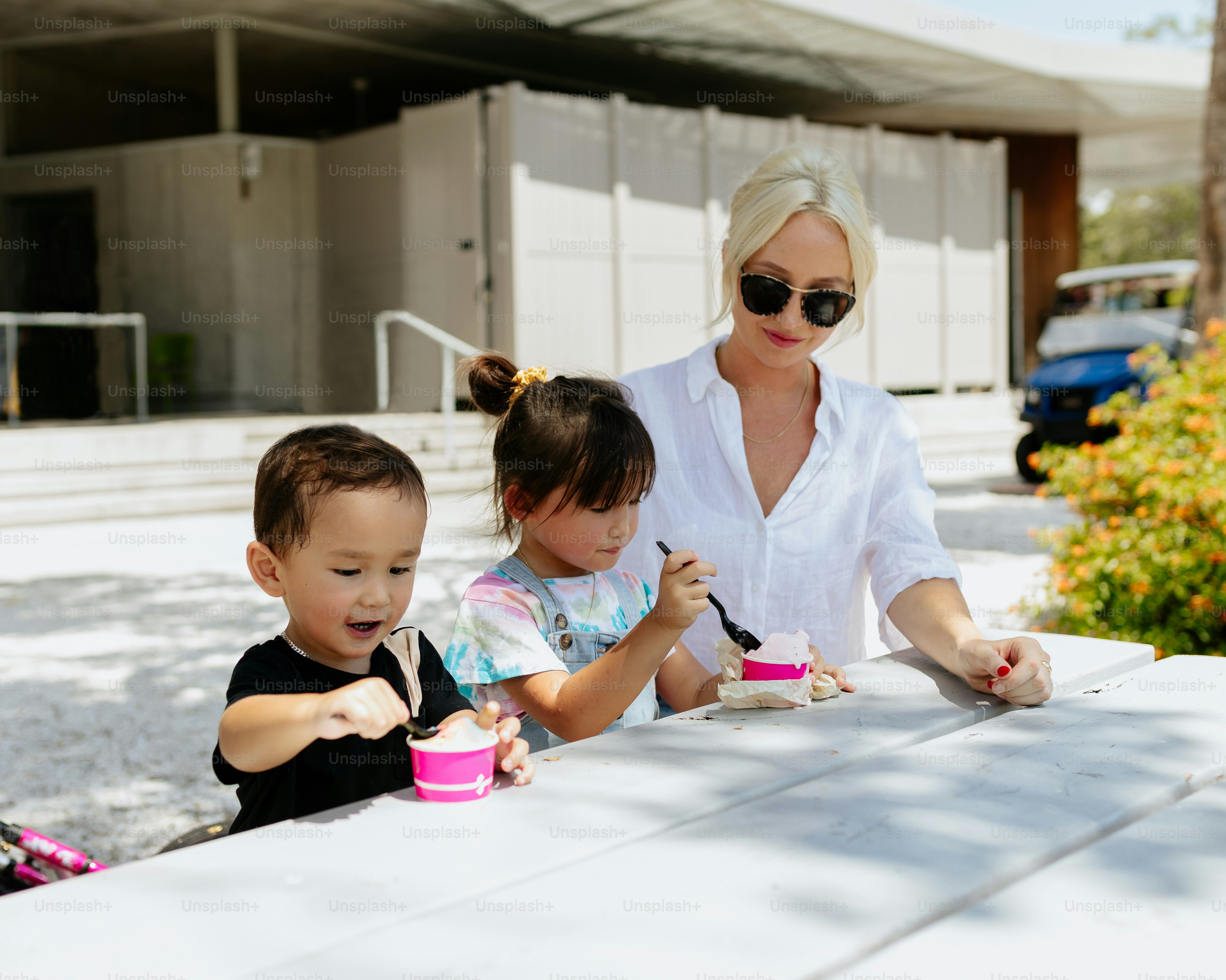 a woman and two children sitting at a table