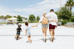 a man, woman, and two children walking in a park