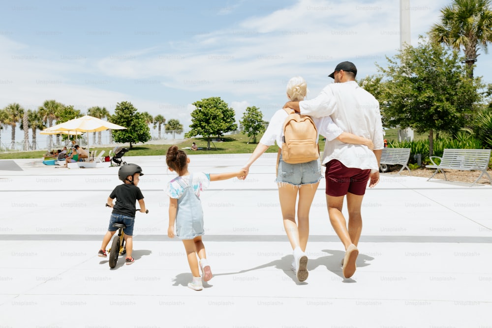 Un uomo, una donna e due bambini che camminano in un parco