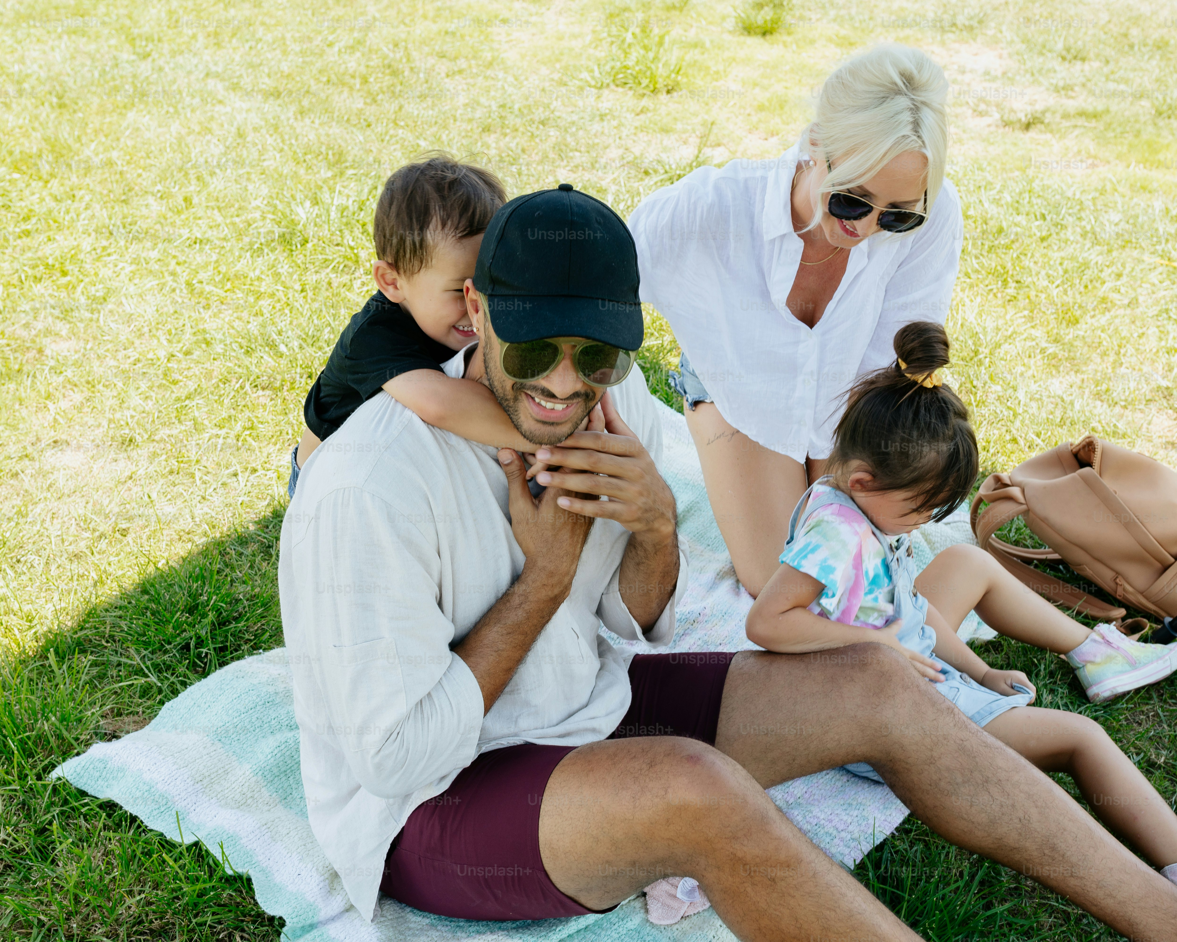 a man sitting on a blanket with two small children