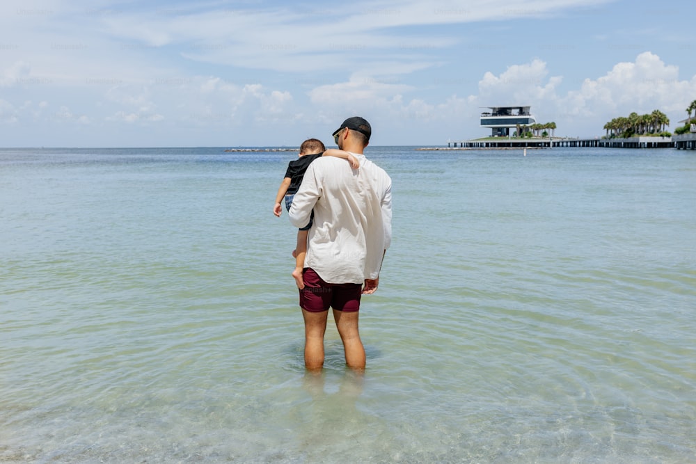a man and a child are standing in the water