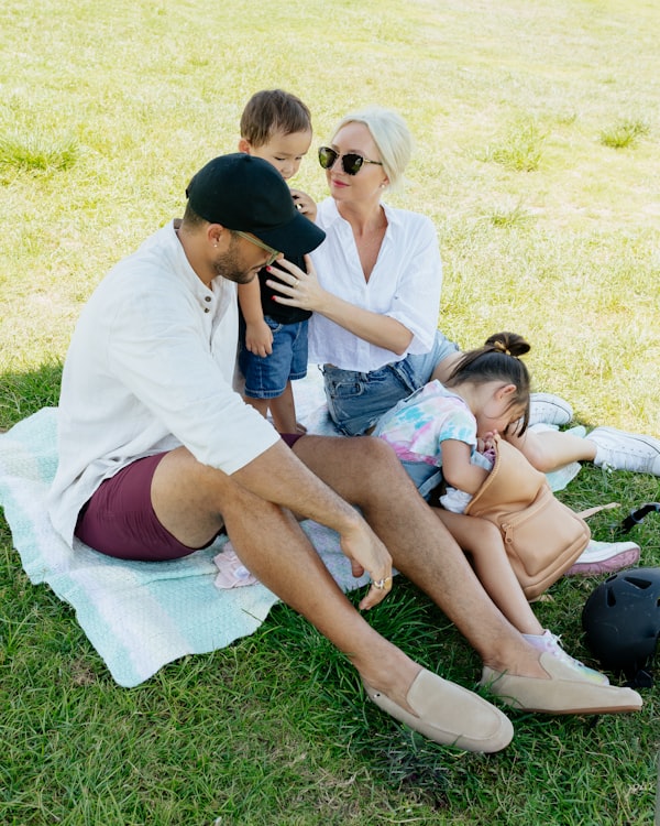 Family with kids on a blanket in the park