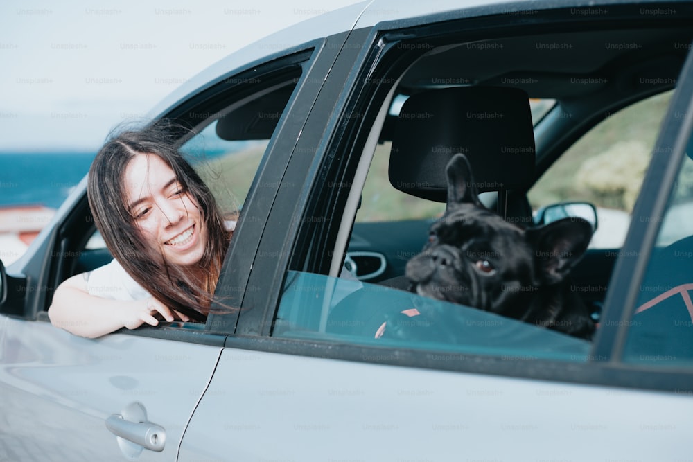 a woman sitting in a car with her dog