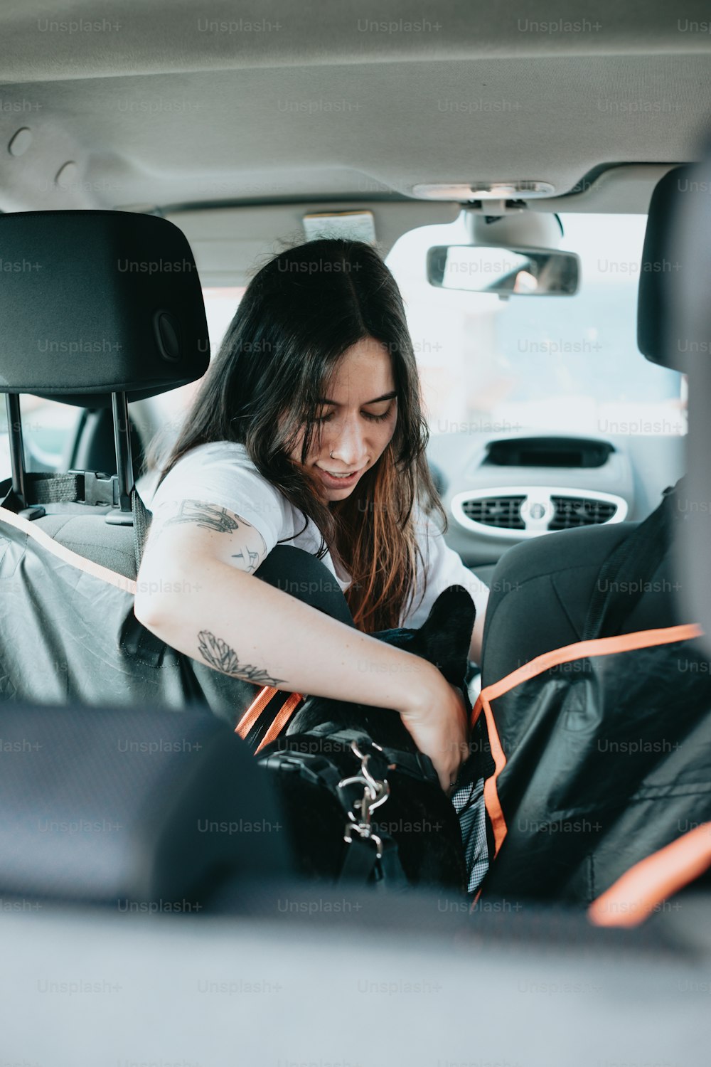Una mujer sentada en el asiento trasero de un coche