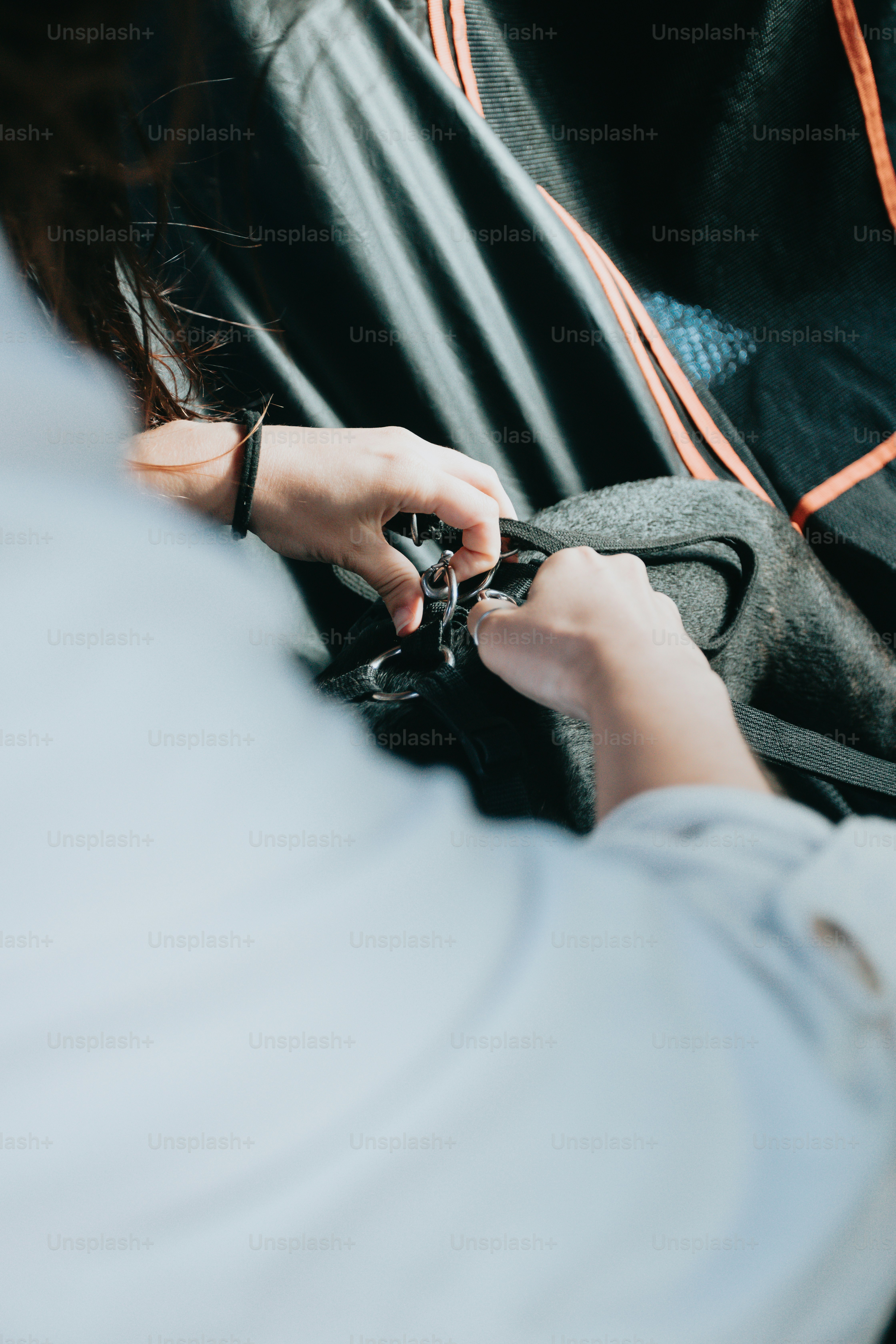 a woman is holding a black purse with her hands