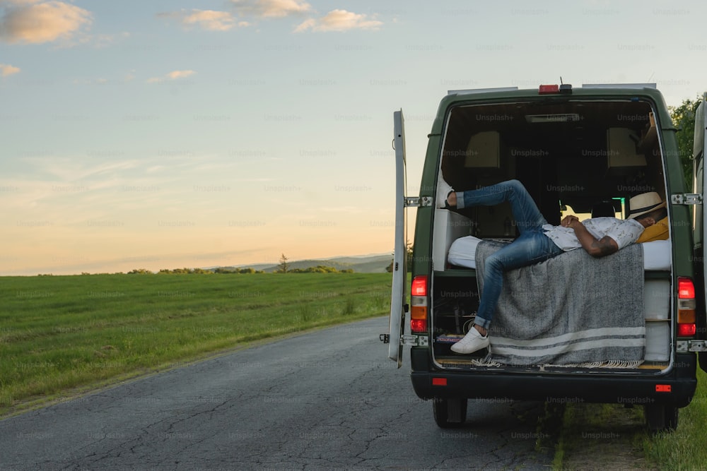 a man laying in the back of a green van