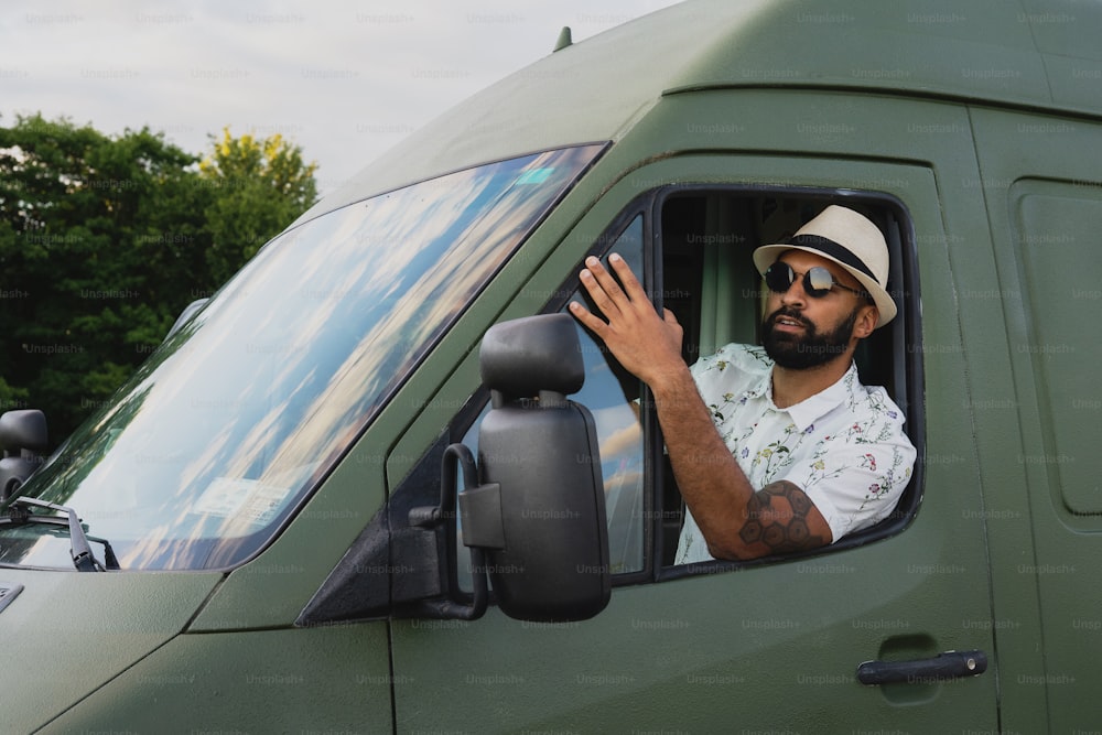 a man with a hat and sunglasses in a truck