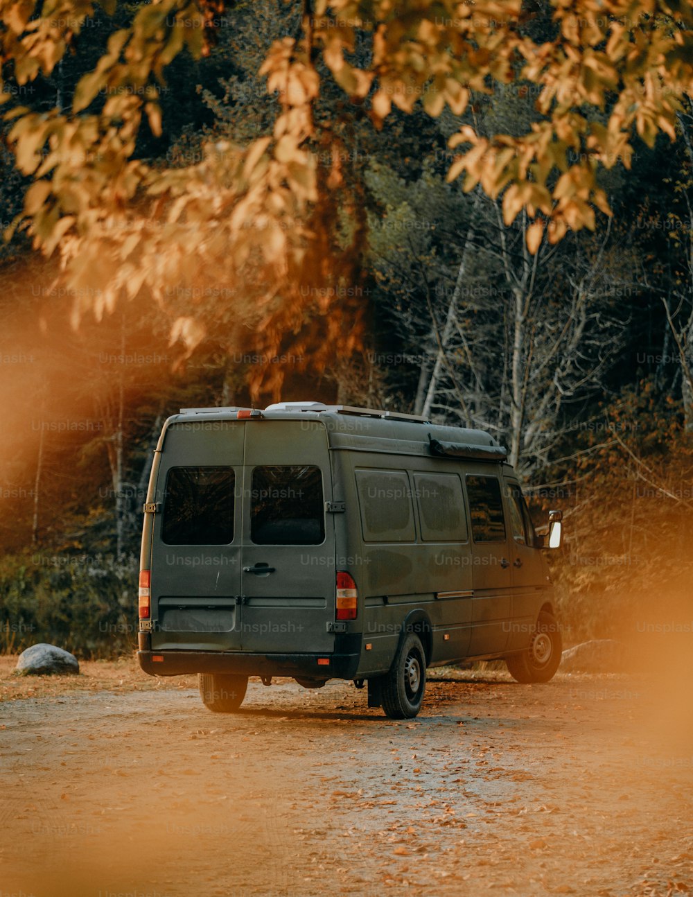 a van is parked on the side of a dirt road