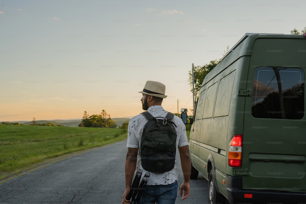 a man with a backpack walking towards a van