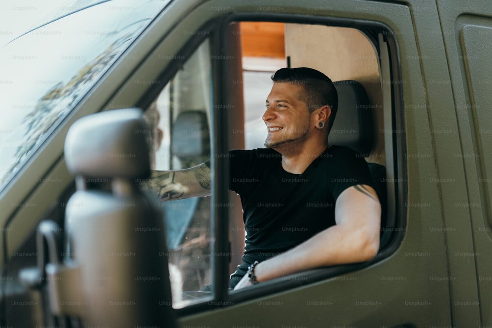a man sitting in a truck looking out the window