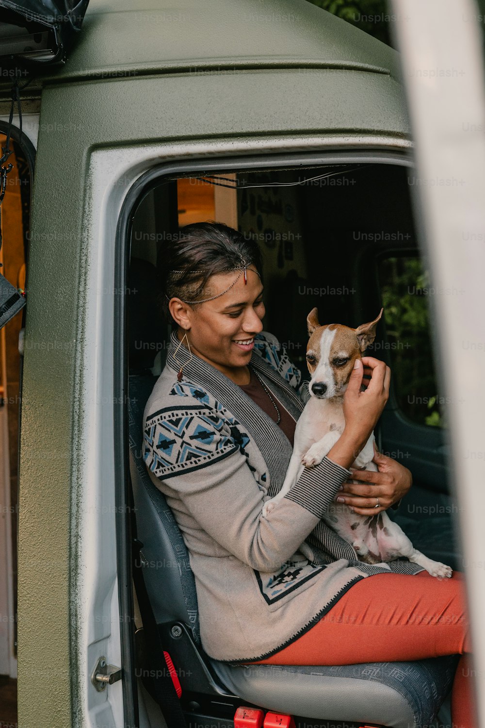 uma mulher sentada na parte de trás de um caminhão segurando um cachorro