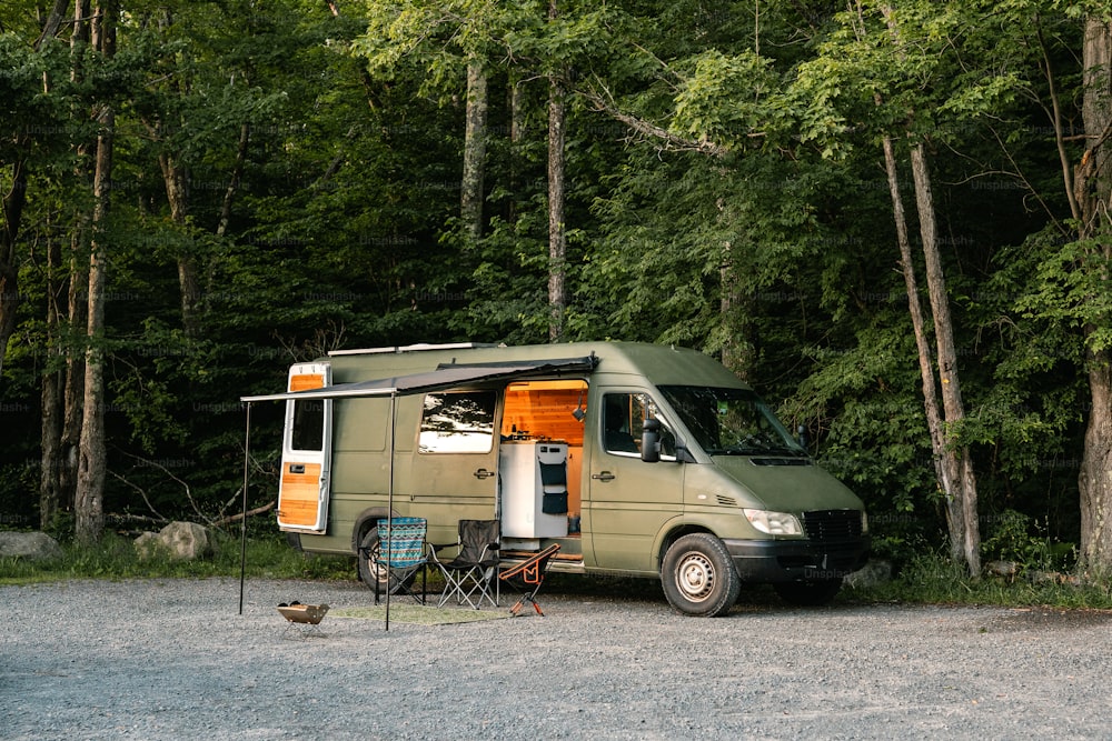 a camper van parked in front of a forest
