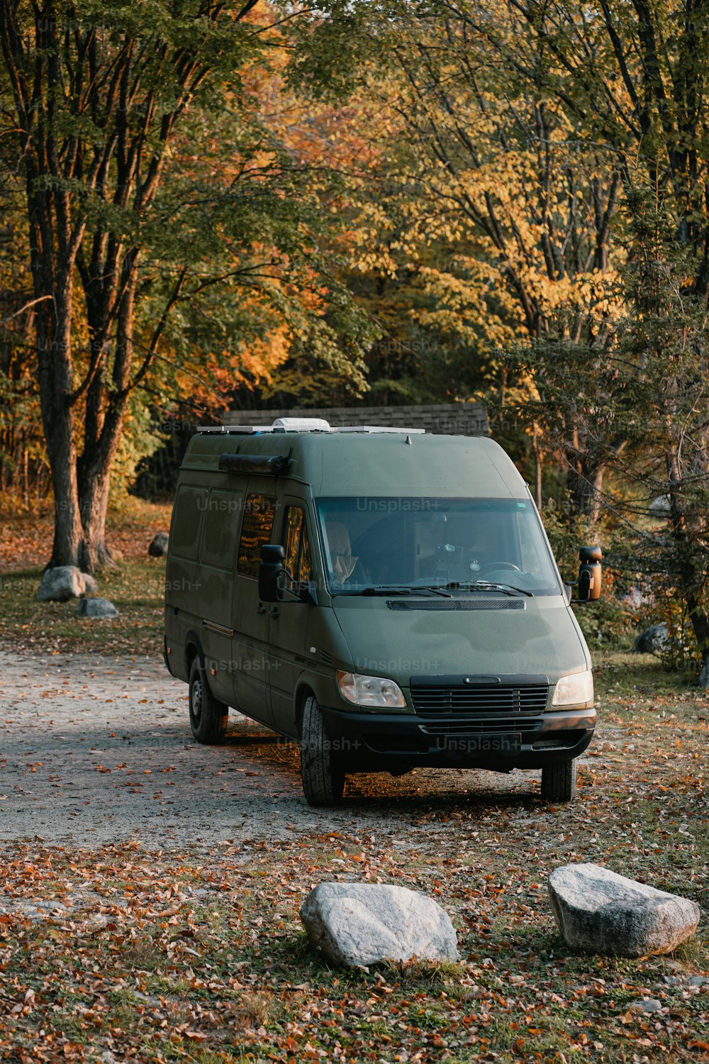 a van is parked in a wooded area
