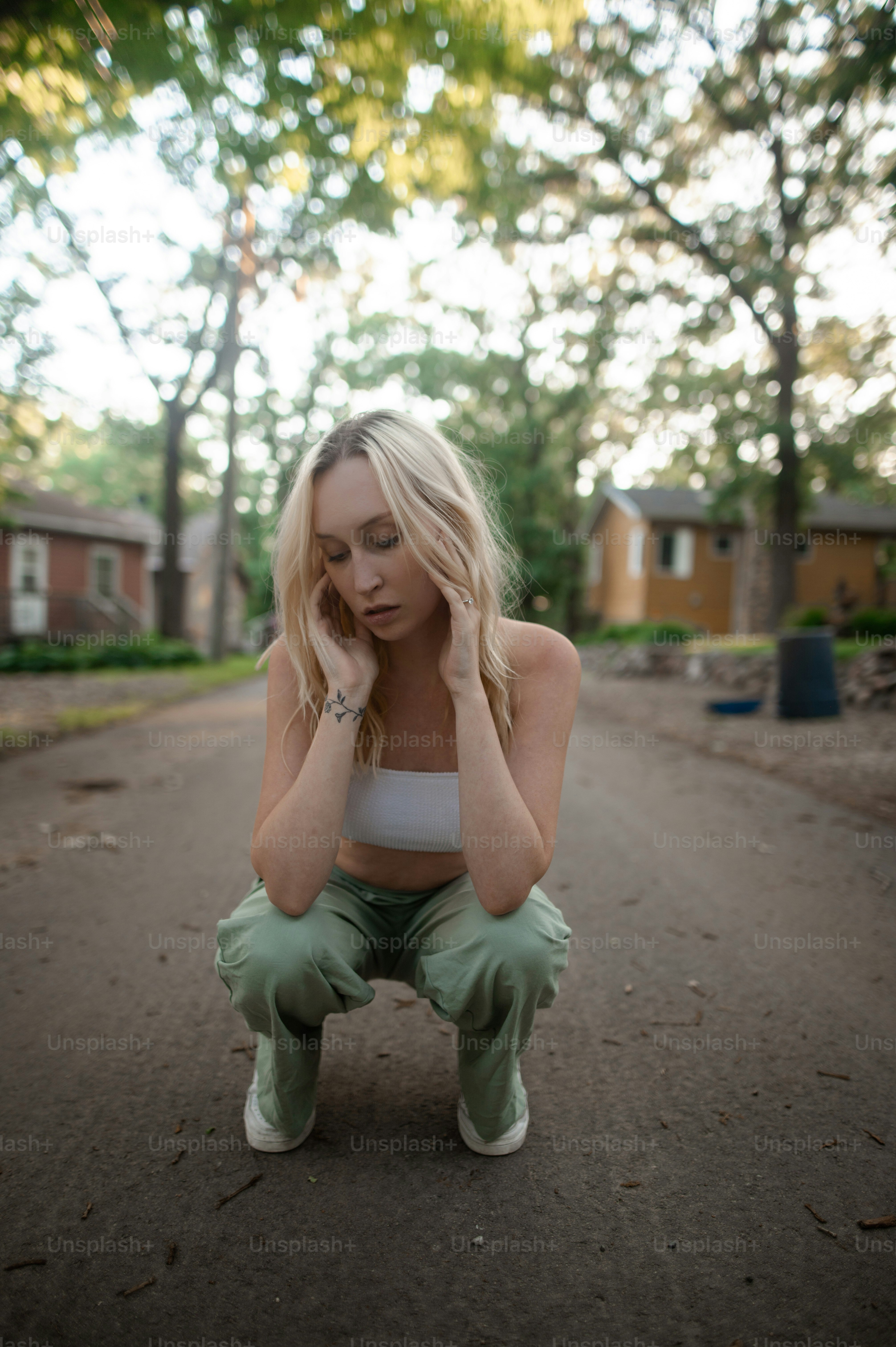 Foto Una mujer en cuclillas en una calle Mujer Imagen en Unsplash
