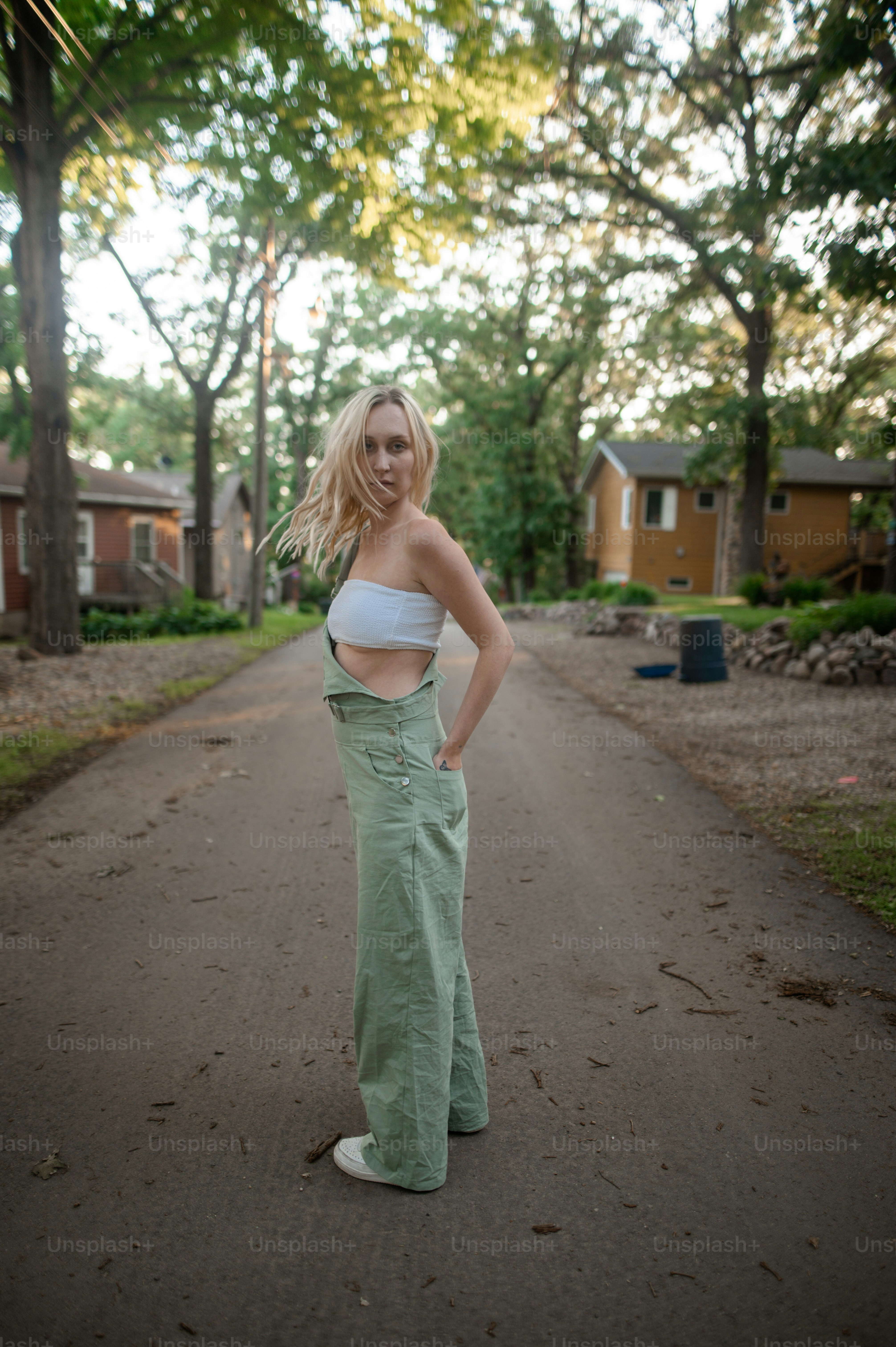 uma mulher em pé em uma estrada com as mãos nos quadris