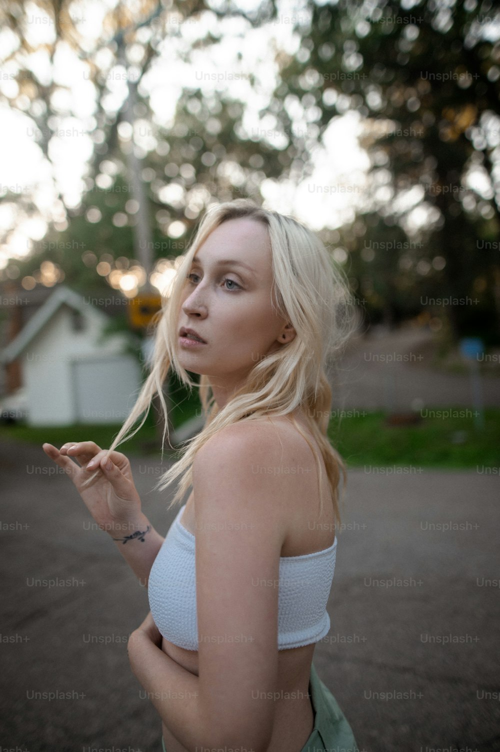 uma mulher em um top branco fumando um cigarro