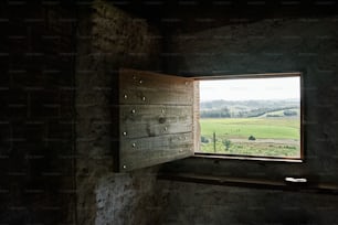 una finestra in un edificio in pietra con vista su un campo