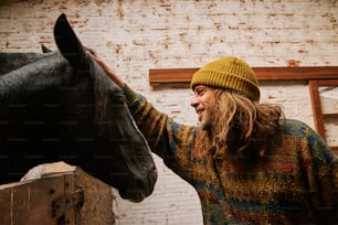 a man petting a horse next to a brick wall