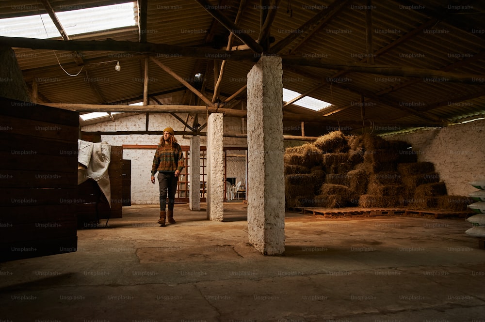 a person standing in a room with stacks of hay