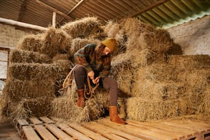 a woman sitting on top of a pile of hay