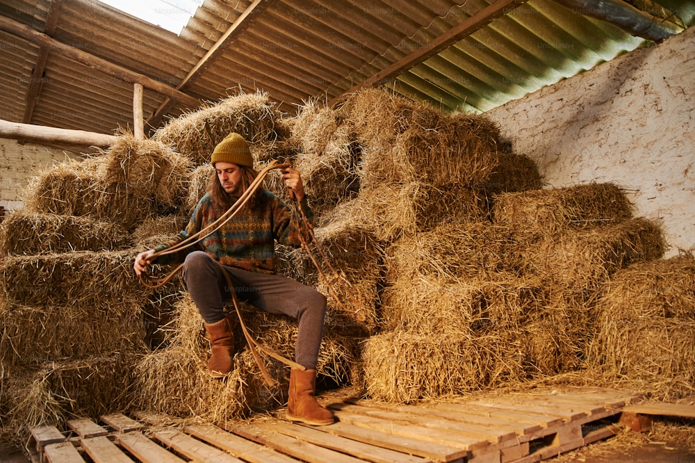 a man sitting on top of a pile of hay