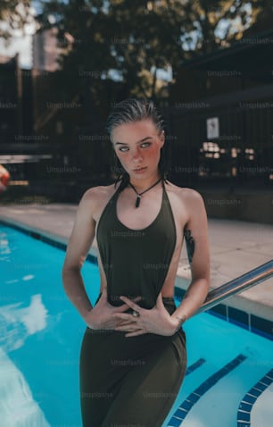 a woman standing in front of a swimming pool