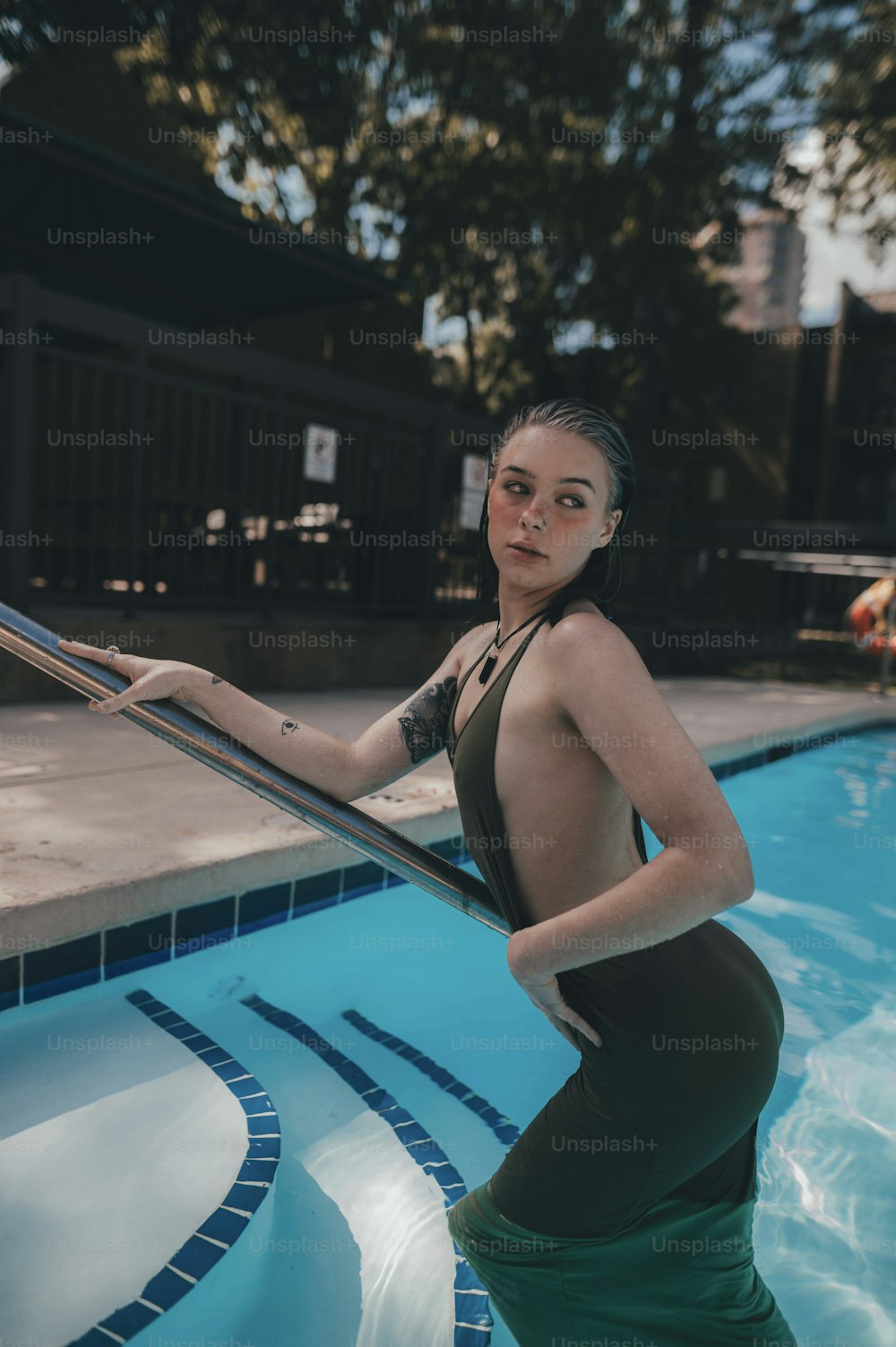 uma mulher em traje de banho em pé em uma piscina