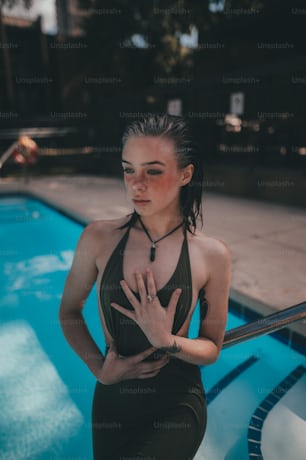 a woman standing next to a swimming pool