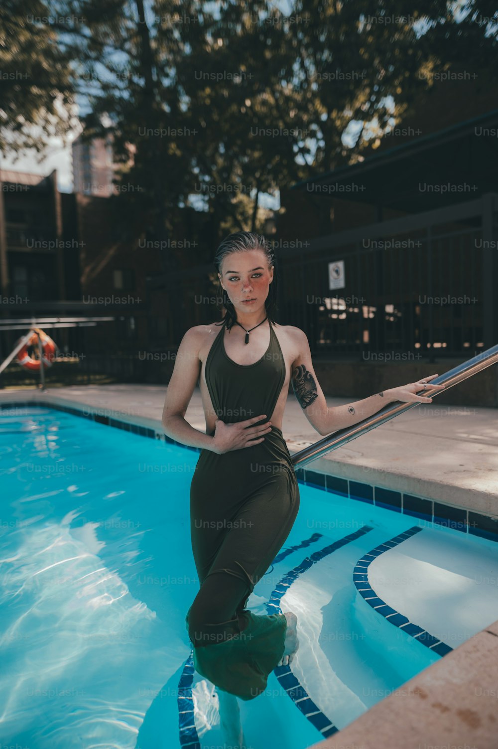 a woman standing in a pool next to a pool