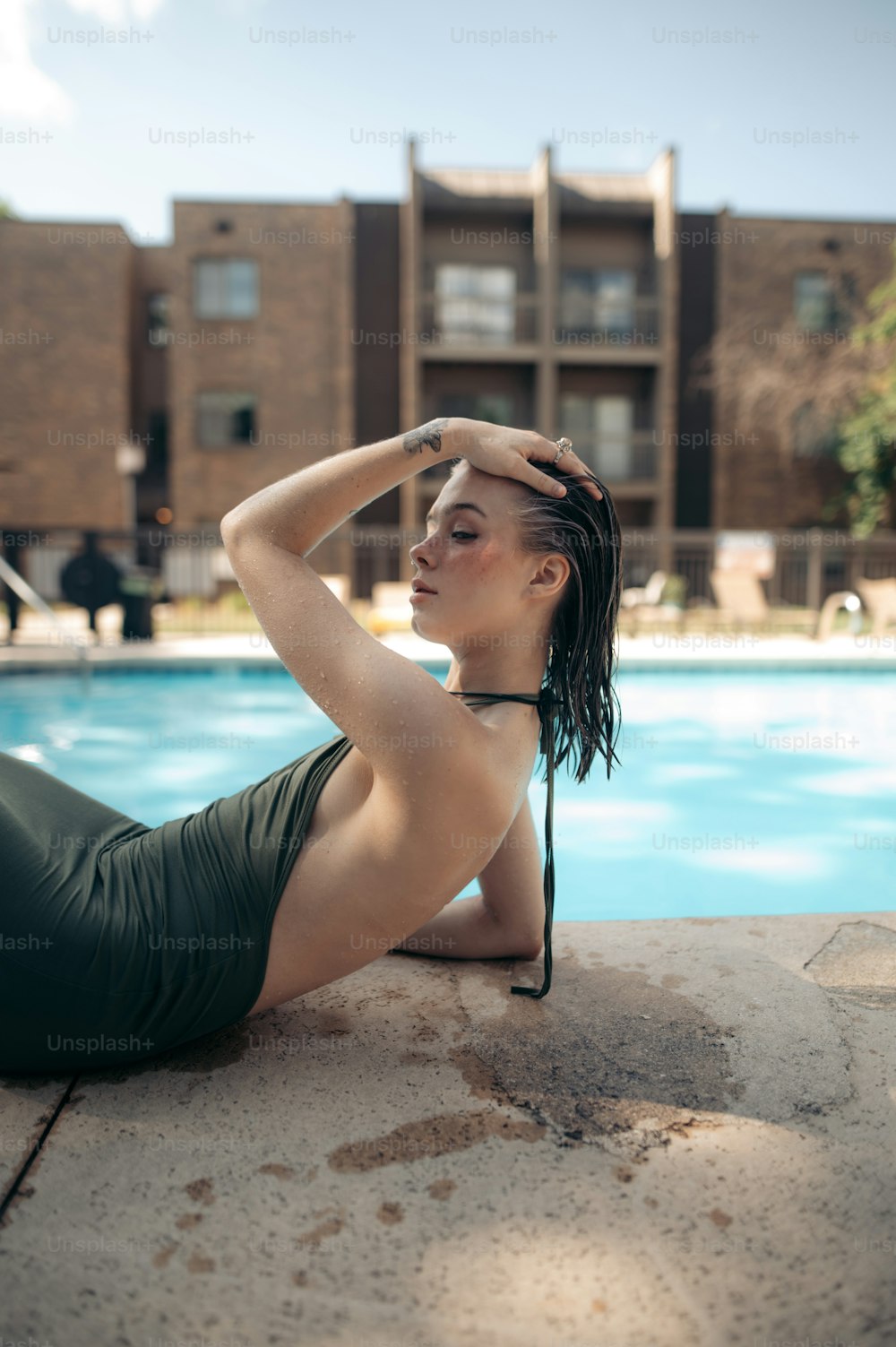 a woman sitting on the edge of a swimming pool