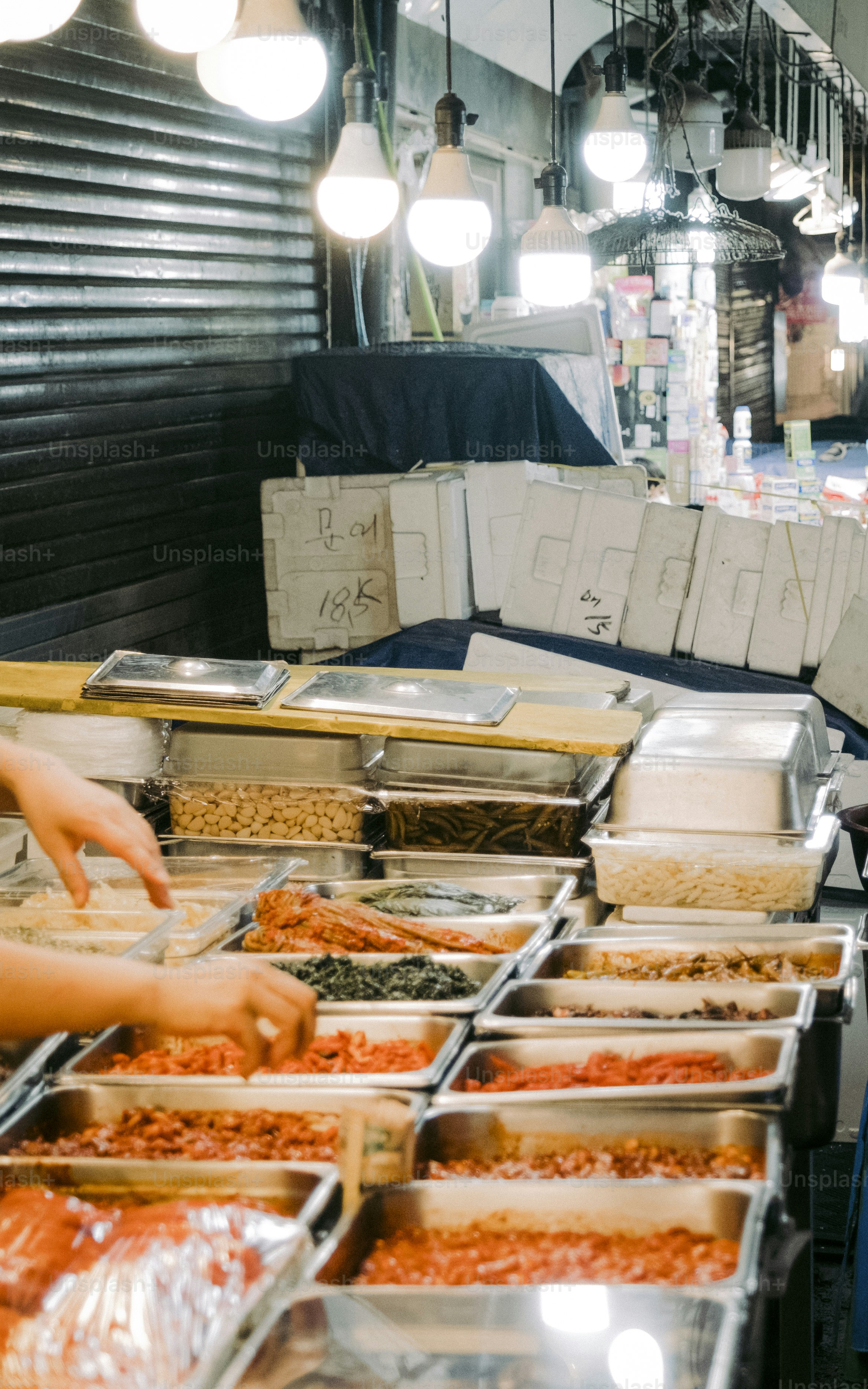 a woman standing in front of a counter filled with lots of food