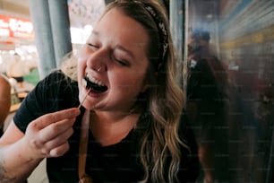 uma mulher comendo comida com uma colher na boca
